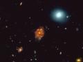 Esta imagen RGB mejorada de 25 segundos de arco de ancho muestra la galaxia "Gran Rueda" con un corrimiento al rojo de 3,25, un gigante cósmico cuya luz ha viajado más de 12 mil millones de años para llegar hasta nosotros