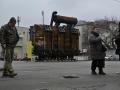La gente pasa junto a un equipo recuperado de una central eléctrica ucraniana atacada por las fuerzas rusas y expuesto en el barrio de Podil de Kiev