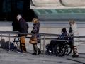 Una mujer empuja una silla de ruedas