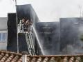 Los servicios de emergencias trabajan para sofocar el incendio en un edificio en la calle Maestro Ripollés.