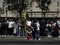 Decenas de personas esperan en una parada de autobús cuyo servicio se ha visto colapsado por el apagón en Barcelona