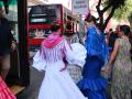 Varias mujeres de flamenca bajan de uno de los autobuses con parada en la Feria