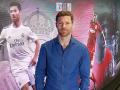 Xabi Alonso posa ante dos fotos suyas jugando para Real Madrid y Liverpool