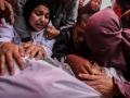 Personas lloran junto a los cuerpos envueltos en sudarios de las víctimas de los ataques israelíes en Yabalia, en el hospital indonesio de Beit Lahia, en el norte de la Franja de Gaza