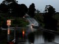 Una carretera inundada por el desbordamiento del arroyo Wallis en Gillieston Heights
