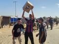Palestinos desplazados reciben paquetes de alimentos de una fundación respaldada por Estados Unidos que se compromete a distribuir ayuda humanitaria en el oeste de Rafah, en el sur de la Franja de Gaza