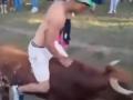 Un joven a lomos de un novillo en un pueblo de Soria