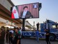 Partidarios de grupos iraquíes proiraníes exhiben una pantalla con el líder supremo de Irán, el ayatolá Alí Jamenei
