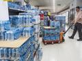 Un reponedor transporta agua en un supermercado, en una imagen de archivo