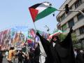 Una mujer iraní sostiene una bandera palestina durante una protesta contra los ataques aéreos israelíes en Teherán
