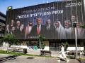 Una mujer pasa junto a una valla publicitaria colocada en Tel Aviv por la iniciativa israelí de seguridad política "Coalición para la Seguridad Regional"