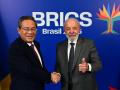 El presidente de Brasil, Luiz Inácio Lula da Silva (der.), saluda con el pulgar al estrechar la mano del primer ministro chino, Li Qiang,