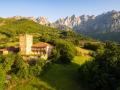 El pueblo con su torre medieval y los Picos de Europa al fondo.