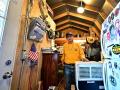 Navajo Nation resident and US veteran who gave his name as "Will" stands beside an air conditioner powered by a generator inside his tiny home which he calls a "tool shed" in Cameron, Arizona, on July 9, 2025 as he waits for electricity from the power grid to reach his residence. Initiatives like "Light Up Navajo," a project launched by the semi-autonomous government of the reservation in 2019, are connecting homes to the power grid with help from volunteer utility crews and federal funding but challenges remain due to the dispersed nature of the communities and vastness of the reservation. (Photo by Frederic J. BROWN / AFP)