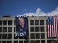 Trabajadores cuelgan una gran foto del presidente estadounidense Donald Trump junto a una bandera estadounidense en la fachada del edificio de la sede del Departamento de Trabajo en Washington, DC