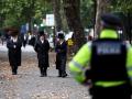 Miembros de la comunidad judía observan cómo la policía patrulla las calles de Stanford Hill, al norte de Londres