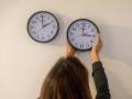 Un mujer prepara los relojes para el cambio de hora de esta madrugada
