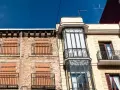 Antiguo edificio residencial con ventanas tapiadas para evitar la entrada de okupas