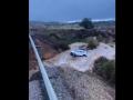 Un coche es arrastrado por el agua tras partirse en dos una carretera en Sevilla