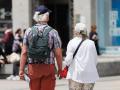 Una pareja de turistas camina en la Puerta del Sol.