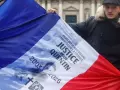 Una bandera francesa con la leyenda "Justicia para Quentin" ondeó durante una manifestación en homenaje al estudiante de 23 años asesinado en Lyon
