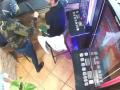El atracador intentando llevar a cabo el robo pero los clientes y el camarero se ríen de él
