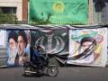Un automovilista pasa junto a pancartas instaladas a lo largo de la carretera con imágenes del líder supremo asesinado de Irán, el ayatolá Ali Khamenei (izquierda), y del líder supremo, el ayatolá Mojtaba Khamenei, en Teherán