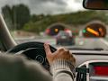 Spanish Basque Country, Spain. "View from the back seats of a car of a man driving on a highway just before entering a lit tunnel."