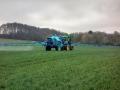 Un tractor aplica fertilizantes sobre la tierra