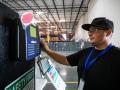 Warehouse worker swiping time card at beginning of shift.
