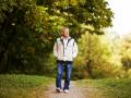 Happy senior man walking and relaxing in park