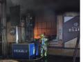 Un bombero afanándose por extinguir las llamas en la cafetería del hotel
