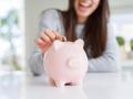 Una joven metiendo dinero en una hucha