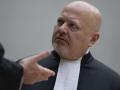 Chief Prosecutor Karim Khan talks prior to the first appearance of former Philippine President Rodrigo Duterte before the International Criminal Court (ICC) on charge of crimes against humanity over his deadly crackdown on narcotics, in The Hague on March 14, 2025. The 79-year-old, the first ex-Asian head of state to face charges at the ICC, followed by videolink during a short hearing to inform him of the crimes he is alleged to have committed, as well as his rights as a defendant. Duterte stands accused of the crime against humanity of murder over his years-long campaign against drug users and dealers that rights groups said killed thousands. (Photo by Peter Dejong / POOL / AFP)