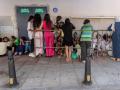 Menores inmigrantes aguardan frente a la sede de la Policía Nacional para iniciar los trámites de identificación y registro en el enclave español de Ceuta