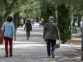 Personas de avanzada edad caminan por un parque de Madrid