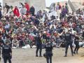 FOTODELDIA CEUTA, 21/08/2026.- La policía vigila a inmigrantes que continúan viviendo en las inmediaciones de la playa del Trampolín en Ceuta, este viernes. El secretario de Estado Juventud e Infancia, Rubén Pérez Correa, ha considerado "factible" llevar a cabo "en un plazo de pocas semanas" el traslado de 500 niñas migrantes no acompañadas desde Ceuta a la Península y, para ello, confía en la "voluntad" del Gobierno de la ciudad autónoma. EFE/Reduan