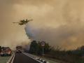 Un avión y coches de bomberos durante las labores de extinción de un incendio forestal, a 27 de agosto de 2026, en la Gola de Pujol, El Saler, Valencia