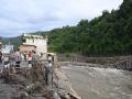 Unas personas permanecen cerca de un puente colapsado tras unas inundaciones repentinas en Devighat, en el distrito nepalí de Nuwakot