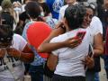 Varias personas se abrazan durante una misa con residentes y familiares de las víctimas del terremoto en los bloques de viviendas estatales de la OPP.