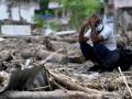 Un hombre se sienta junto a los escombros mientras recupera sus pertenencias tras unas inundaciones repentinas en Devighat, en el distrito nepalí de Nuwakot