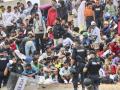 Un grupo de policías custodiando a un grupo de inmigrantes ilegales en Ceuta