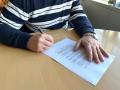 Una persona firma un contrato de trabajo.
