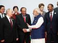 El primer ministro indio, Narendra Modi, saluda a su homólogo malasio, Anwar Ibrahim, ante la mirada de Vladimir Putin.