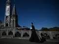 Un sacerdote pasa junto a la Basílica de Notre-Dame du Rosaire cinco días antes de la visita del papa León XIV a este lugar