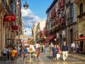 Varias personas disfrutan de una soleada tarde en la calle Ancha de León