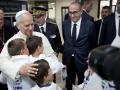 León XIV abraza a unos niños del coro en presencia del arzobispo de Metz, Philippe Ballot (izquierda), el prefecto del departamento de Mosela, Pascal Bolot (3.º por la izquierda), y el ministro del Interior francés, Laurent Núñez, a su llegada al aeropuerto de Metz-Nancy-Loren