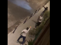 Uno de los delincuentes, abajo, apunta a los dos agentes mientras porta una escopeta
