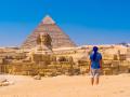 Turista frente a la Esfinge y las Pirámides de Guiza