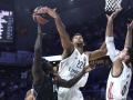 El pívot del Real Madrid Edy Tavares (c) lucha por un balón en un partido de Euroliga